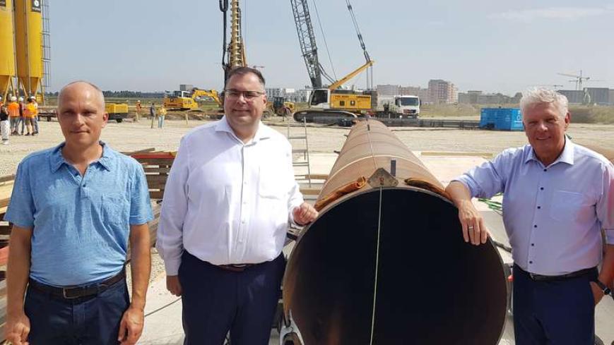 Der Oberbürgermeister zusammen mit dem Geschäftsführer der MVG und Baudirektor Schnabel auf der Baustelle Freiham, posierend vor einem Leerrohr